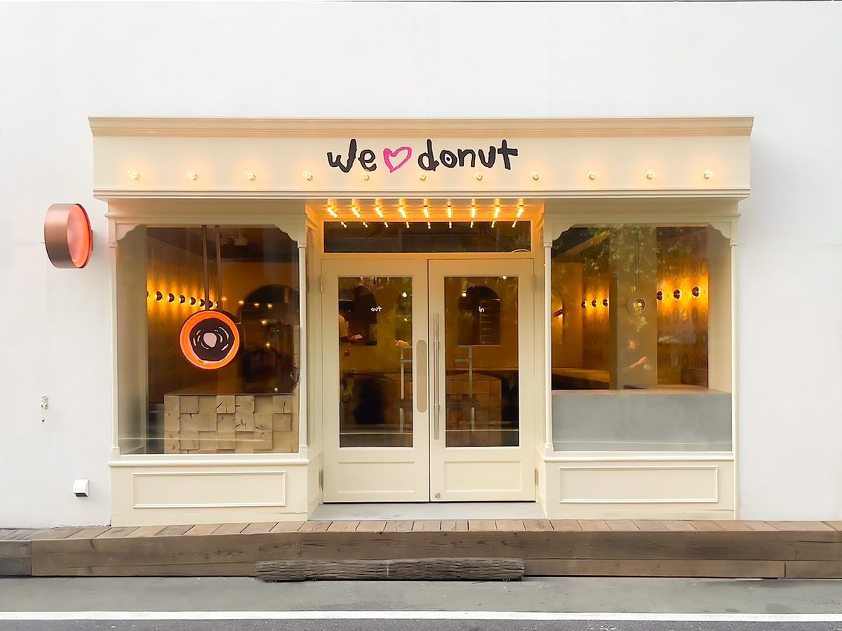 2024年の開業時のプレスリリースで公開された we♡donut 自由が丘の外観。クリーム色の店構えに「we♡donut」の文字、左にドーナツ形の丸い看板
