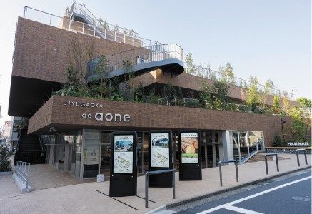 JIYUGAOKA de aone の外観。低層の建物の入り口上に「JIYUGAOKA de aone」の表示がある。