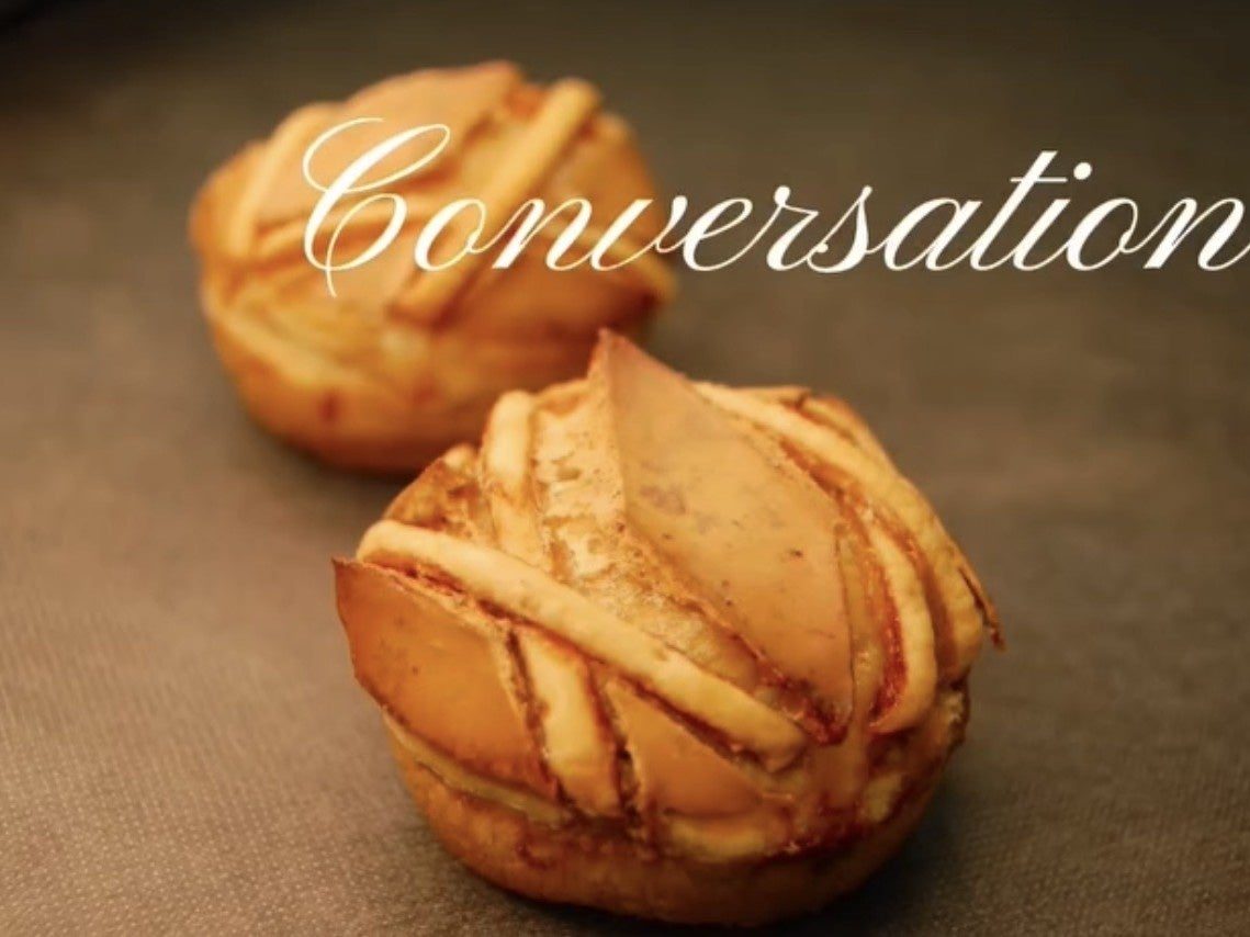 「Conversation」の文字が薄く乗せられた、クリーム系の焼き菓子のクローズアップ