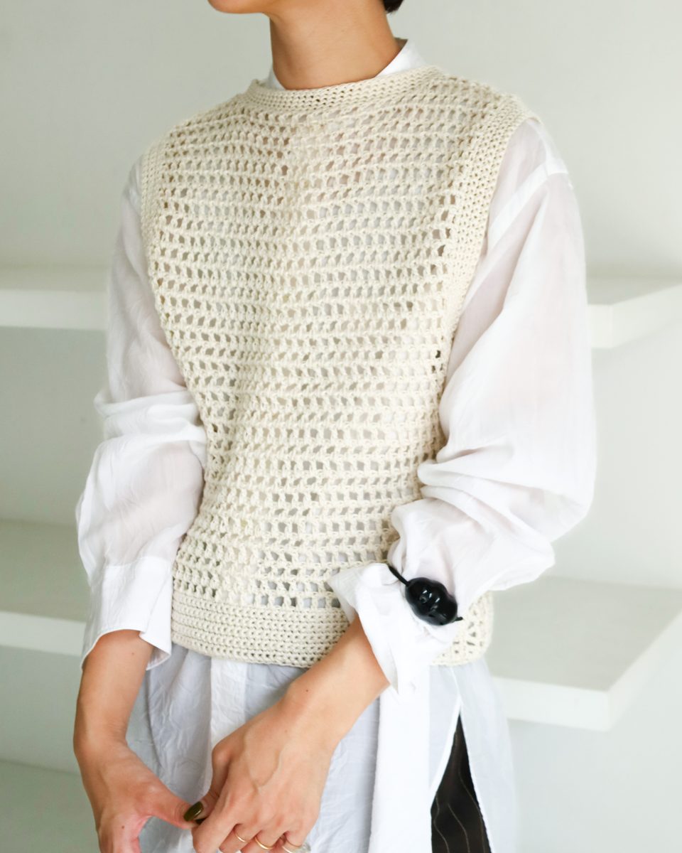 店舗告知で公開された SABLE VEST。白いシャツの上に重ねた、網目状に編まれたきなり色のベスト