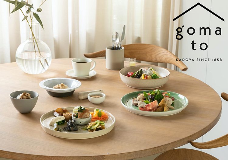 2022年の開店時に公開されたgoma toの料理。丸いテーブルにごまを使った皿が並び、右上にgoma toのロゴ