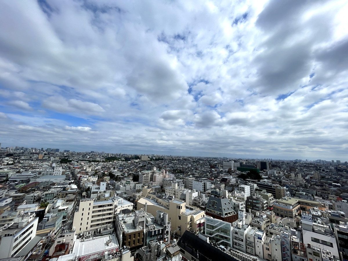 プレスリリースで公開された15階からの眺望。曇り空の下、低層から中層の建物が地平線まで広がっている