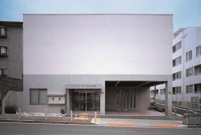 宮本三郎記念美術館の正面外観。灰色の壁面と入口、右手にゲート状の通路。住宅街の一角に建つ低層の建物